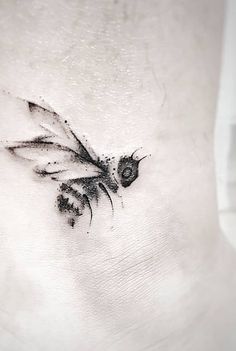 a black and white photo of a bee on the side of a woman's stomach