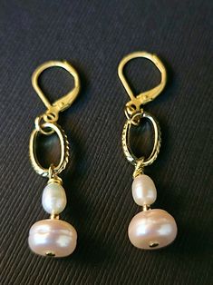 Make a statement with these stunning White Baroque Pearl drop earrings! Featuring textured oval chain links and classic lever back ear wires, these earrings are both elegant and unique. The button cap pearls measure 9.20mm x 6.0mm and are accented with small oval freshwater pearls and gold beads for added sophistication. With a 1 3/4 drop in length, these earrings beautifully showcase the pearls' nice luster and glow. Perfect for adding a touch of timeless glamour to any outfit. Classic Pink Dangle Earrings, Classic Pink Dangle Jewelry, Classic Handmade Oval Link Jewelry, Elegant Handmade Oval Pearl Earrings, Elegant Oval Jewelry With French Hook, Elegant Pink Earrings For Everyday Wear, Pink Elegant Everyday Earrings, Elegant Pink Everyday Earrings, Elegant Nickel-free Oval Link Jewelry