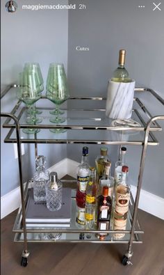 a bar cart with liquor bottles and glasses on it