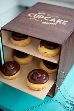 cupcakes in a wooden box with chocolate frosting