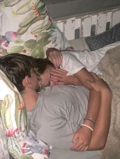 a man and woman laying in bed with their heads touching each other's noses