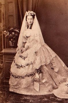 an old black and white photo of a woman in a wedding dress