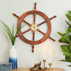 a wooden table topped with candles and a decorative ship wheel wall mounted on the wall