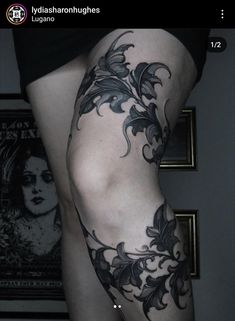 a woman's thigh with black flowers on it and the bottom part of her leg