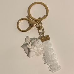 a keychain with an angel on it and a piece of lace attached to it