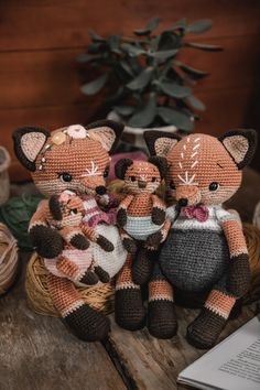 three crocheted stuffed animals sitting next to each other on top of a wooden table