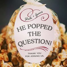 a bag full of popcorn with the words he popped the question written on it and a tag that says, thank you for joining us