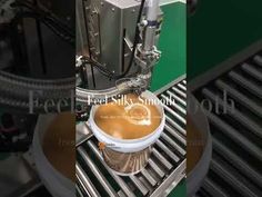 an automatic coffee cup making machine with liquid in the bottom, and on top of it's conveyor belt