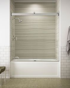 a bathroom with a bathtub and tiled walls