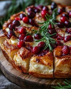 a cranberry and cheese pizza on a cutting board with rosemary sprigs