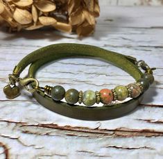 a green leather bracelet with beads and charms