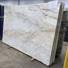 a large marble slab is on display in a store with blue and yellow boxes behind it