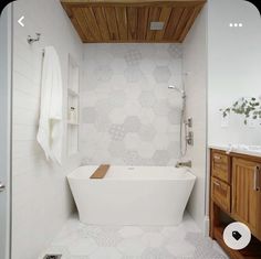 a white bath tub sitting next to a wooden cabinet