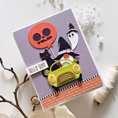 a halloween card with a green car and two black cats on it, surrounded by spooky decorations