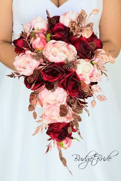 a bridal holding a bouquet of red and pink flowers