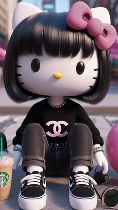 a hello kitty doll sitting on the ground next to a cup of coffee and some donuts