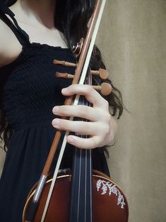 a woman in black dress holding a violin