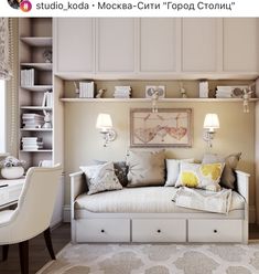 a white day bed sitting under a window next to a desk