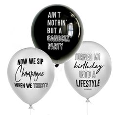 three black and white balloons with sayings on them