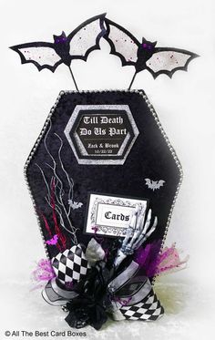 a black and white box with bat decorations on the top is decorated in purple and black