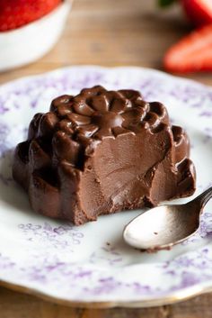 a piece of chocolate cake on a plate with a spoon