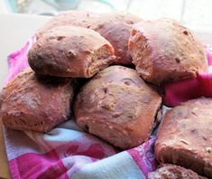 a pile of bread sitting on top of a pink and white towel