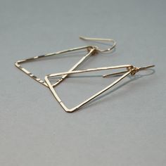 "Gorgeous and linear, these lightweight gold triangle earrings are hand shaped and forged to a glittering finish. Also available in rose gold filled and tarnish resistant sterling silver. These earrings are in it for the long haul : we only use high quality 14k gold fill, which (unlike gold plate) will never wear off or change color no matter how much you wear them. The silver we use is high quality and tarnish resistant. As long as you keep them clean they will be just as bright as the day they Minimalist Triangle Nickel-free Earrings, Minimalist Nickel-free Triangle Earrings, Gold Triangle Minimalist Earrings, Minimalist Gold Triangle Earrings, Elegant Triangle Metal Earrings, Everyday Triangle Nickel-free Jewelry, Everyday Nickel-free Triangle Jewelry, Nickel-free Gold Triangle Jewelry, Modern Nickel-free Triangle Earrings