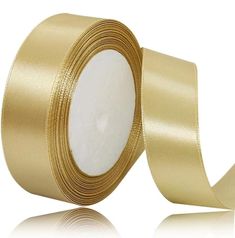 a roll of gold satin ribbon on a white background