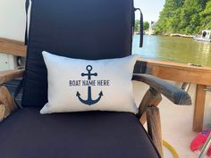 a chair with a pillow that says boat name here and an anchor on the back