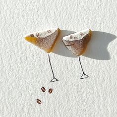 two small pieces of food with legs sticking out of the ground, on top of each other