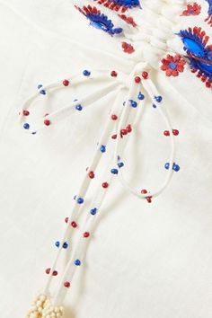 an embroidered white shirt with red, white and blue beads