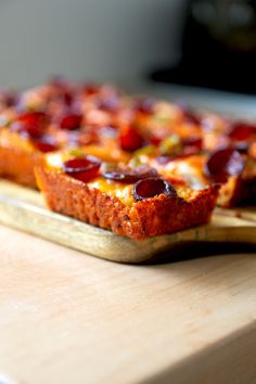 a pizza sitting on top of a wooden cutting board