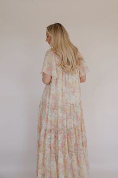 This beautiful Spring Blooms Maxi Dress is perfect for any spring and summer occasion. The flutter sleeves add a feminine touch, while the tiered skirt gives it a flowy, bohemian feel. The stunning floral print adds a pop of color. The maxi length makes it versatile for formal occasions or a casual day out. The lightweight fabric ensures you stay cool and comfortable in warm weather. colors in the dress: pink, white, green and yellow lined relaxed loose fit flutter sleeves smocked top tiered ski