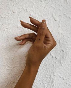 a woman's hand with two fingers on the wall