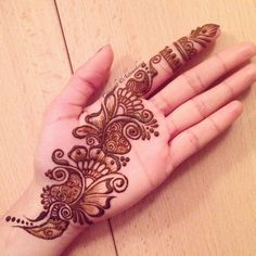 a woman's hand with henna tattoos on it