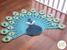 a crocheted peacock rug is sitting on the floor