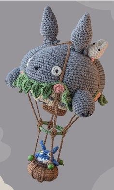 a crocheted stuffed animal on top of a hot air balloon with two mice