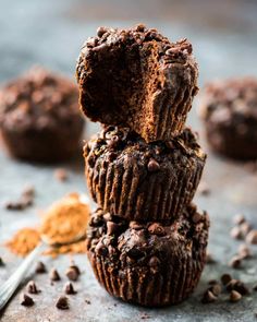 three chocolate muffins stacked on top of each other with one bite taken out