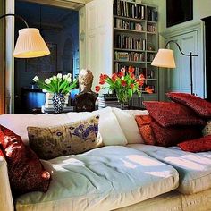 a living room filled with lots of furniture and flowers in vases on the table