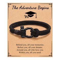 a black rope bracelet with an anchor clasp and the words, the adventure begins behind it