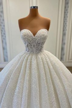 a white ball gown on a mannequin dummy with beading and sequins