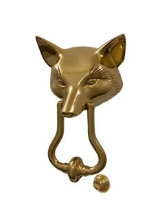 a gold metal fox head hook on a white wall