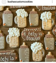 baby is brewing decorated cookies are displayed on a wooden table with white frosting and brown trimmings