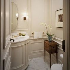 a bathroom with a sink, toilet and vanity in it's corner area next to a mirror