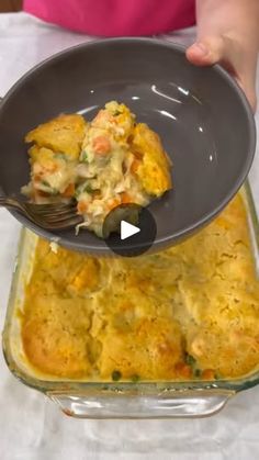 a person scooping food out of a casserole dish