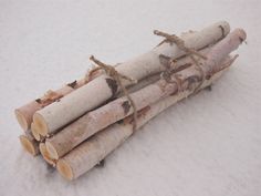 a pile of logs sitting on top of snow covered ground