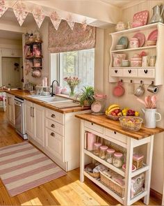 a kitchen filled with lots of pink and white decor on top of wooden counter tops