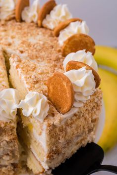 a close up of a cake on a plate with some bananas in the back ground