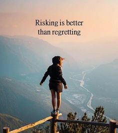 a woman standing on top of a wooden fence next to a mountain with a quote