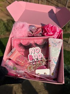 a pink box filled with makeup and accessories